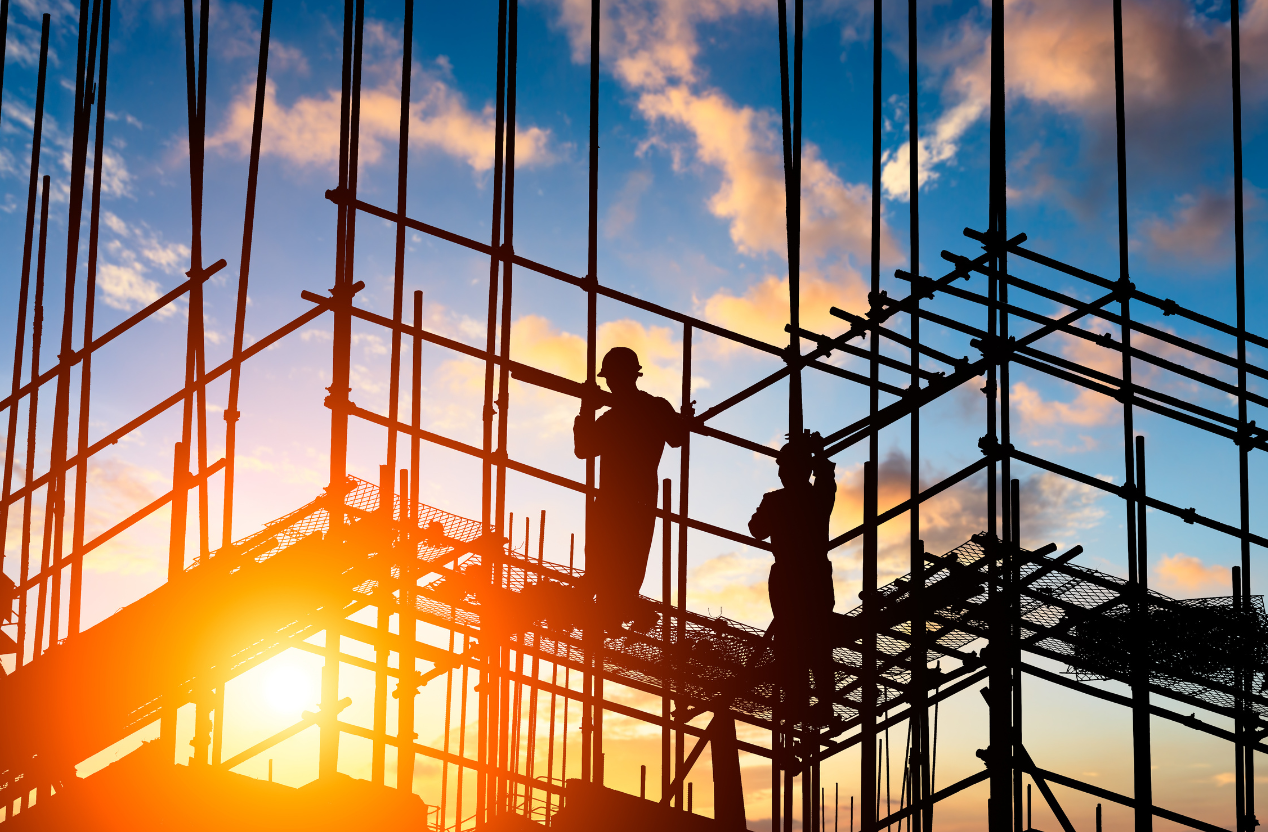 Construction workers on scaffolding at dusk